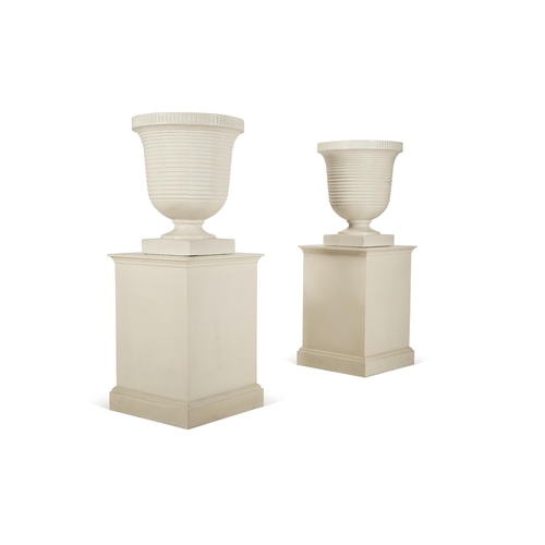 148 - A PAIR OF WHITE PAINTED COMPOSITION STONE RIBBED URNS OF LARGE SIZEMODERNOn white patinated wooden p... 