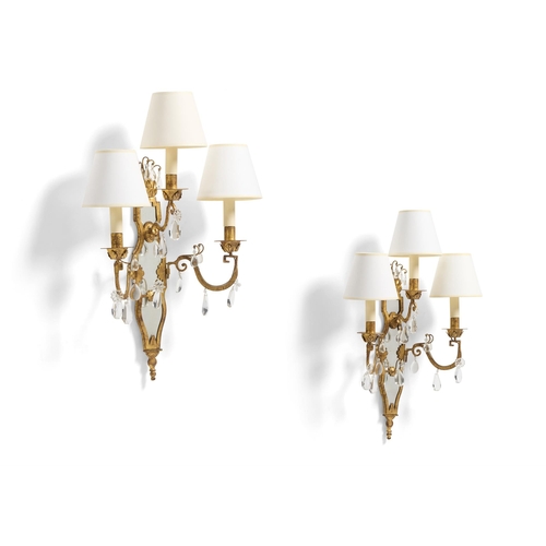 162 - A PAIR OF GILT METAL AND MIRRORED THREE-BRANCH WALL LIGHTSMID 20TH CENTURYHung with facetted glass b... 