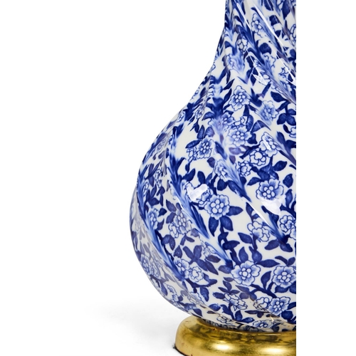 227 - A BLUE AND WHITE FLORAL DECORATED SPIRAL FLUTED POT-BELLIED VASE LATE 19TH CENTURYLater wired for el... 