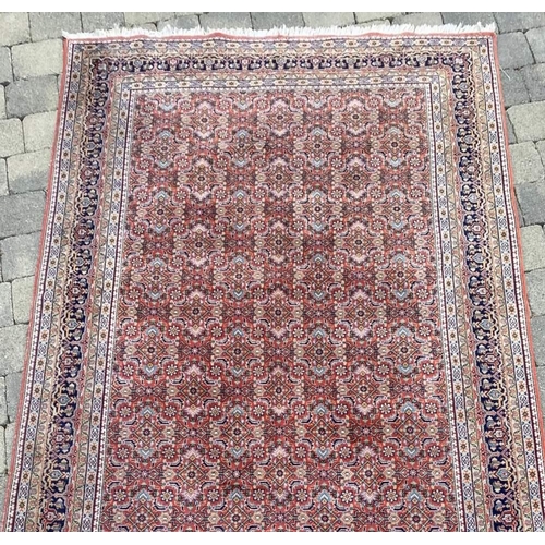 130 - A GOOD BIDJAR FLOOR RUG with main rust and blue colours, multiple borders of various colours and mot... 