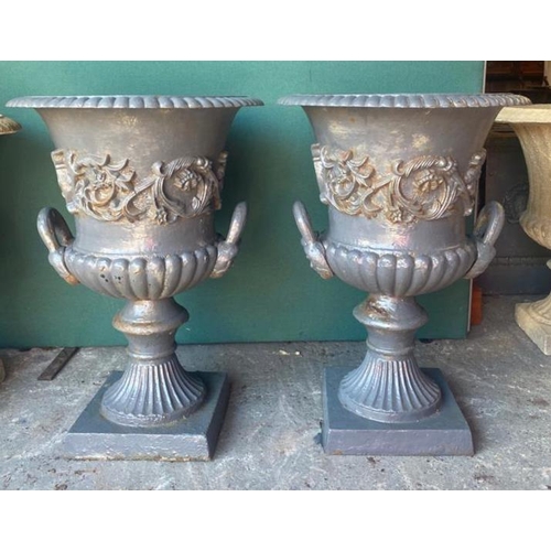 146 - A PAIR OF IRISH 19TH CENTURY HEAVY CAST IRON GARDEN URNS ON PLINTHS, urns decorated with turn over g... 