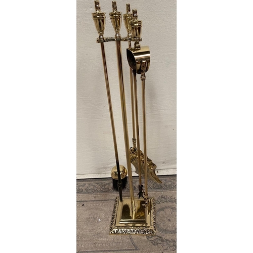 189 - A FOUR PIECE BRASS FIRE IRON SET, with shovel, brush, poker and tongs, all on a stand, the base of w... 