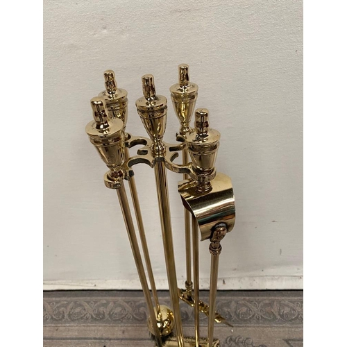 189 - A FOUR PIECE BRASS FIRE IRON SET, with shovel, brush, poker and tongs, all on a stand, the base of w... 