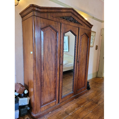 201 - A LATE 19TH CENTURY THREE DOOR MAHOGANY GENTLEMAN’S WARDROBE, with mirror, panelled doors and engrav... 