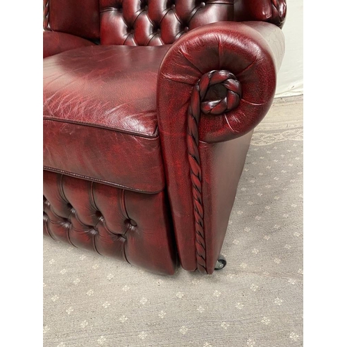 215 - A GOOD QUALITY OX BLOOD LEATHER WING BACK RECLINER ARMCHAIR, with deep buttoned back, and rope detai... 