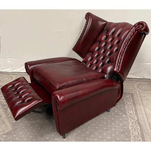 215 - A GOOD QUALITY OX BLOOD LEATHER WING BACK RECLINER ARMCHAIR, with deep buttoned back, and rope detai... 