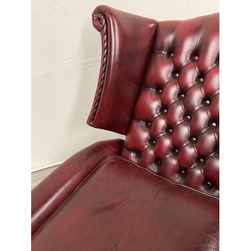 215 - A GOOD QUALITY OX BLOOD LEATHER WING BACK RECLINER ARMCHAIR, with deep buttoned back, and rope detai... 