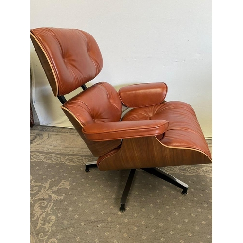 216 - A TAN LEATHER RECLINER CHAIR IN THE EAMES STYLE, with matching foot stool