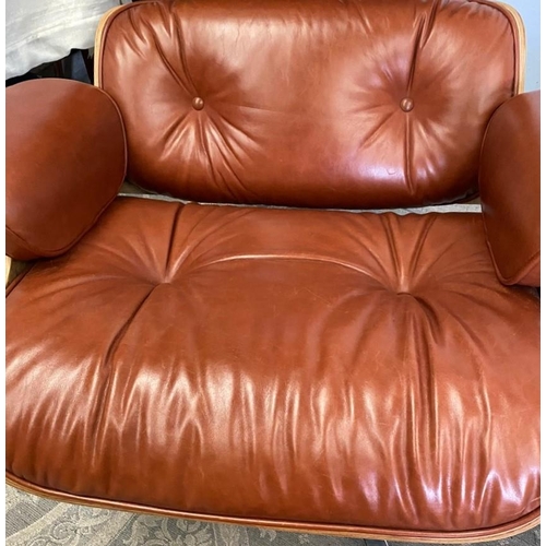 216 - A TAN LEATHER RECLINER CHAIR IN THE EAMES STYLE, with matching foot stool