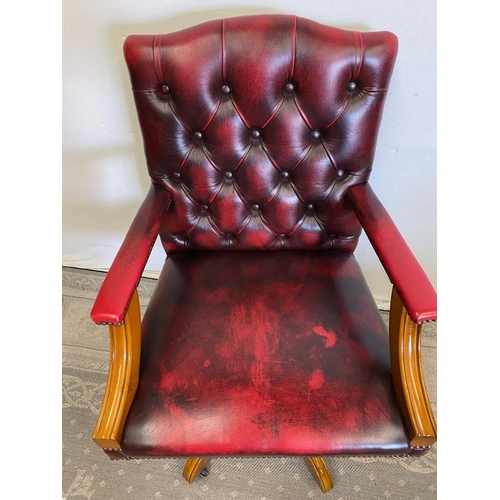 235 - A RED LEATHER OFFICE / DESK CHAIR, with walnut frame, swivels on base, 99cm tall to the back, 62cm x... 