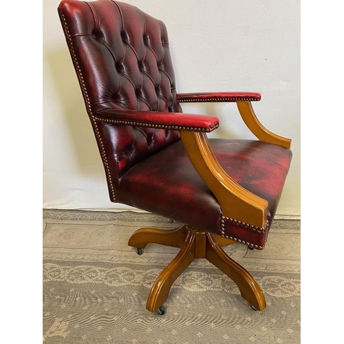 235 - A RED LEATHER OFFICE / DESK CHAIR, with walnut frame, swivels on base, 99cm tall to the back, 62cm x... 