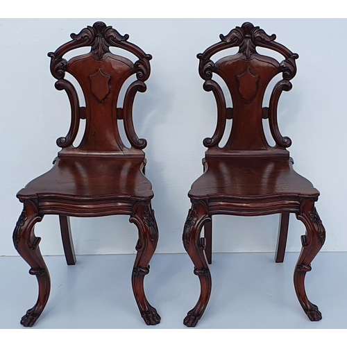 33 - A VERY FINE PAIR OF 19TH CENTURY IRISH MAHOGANY HALL CHAIRS, each with a carved back support with sc... 