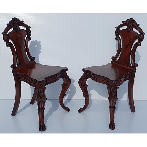 33 - A VERY FINE PAIR OF 19TH CENTURY IRISH MAHOGANY HALL CHAIRS, each with a carved back support with sc... 