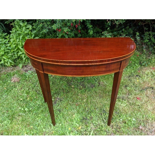 34 - A VERY FINE GEORGIAN MAHOGANY FOLD OVER TEA TABLE, circa 1800, with D shaped top having satinwood st... 