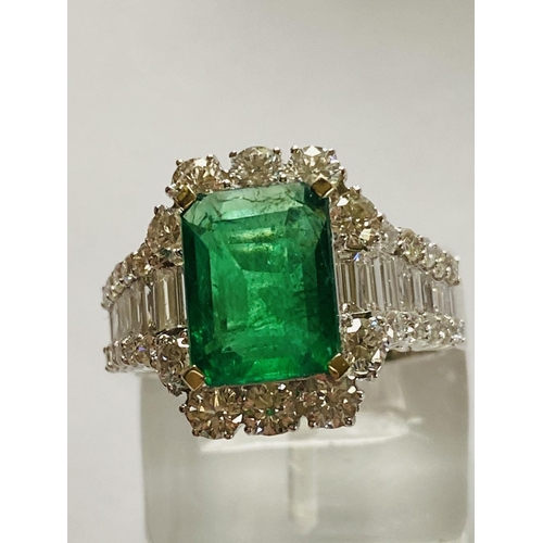 4 - A STUNNING 18CT WHITE GOLD COLUMBIAN EMERALD AND DIAMOND CLUSTER RING, the central emerald weighs 2.... 