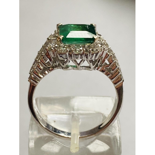 4 - A STUNNING 18CT WHITE GOLD COLUMBIAN EMERALD AND DIAMOND CLUSTER RING, the central emerald weighs 2.... 