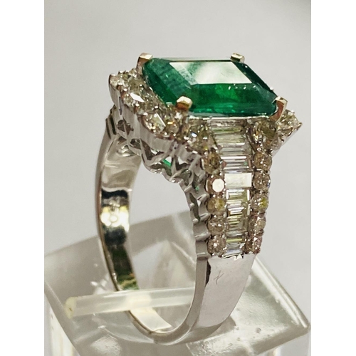 4 - A STUNNING 18CT WHITE GOLD COLUMBIAN EMERALD AND DIAMOND CLUSTER RING, the central emerald weighs 2.... 