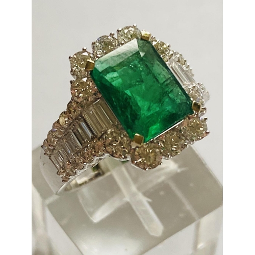 4 - A STUNNING 18CT WHITE GOLD COLUMBIAN EMERALD AND DIAMOND CLUSTER RING, the central emerald weighs 2.... 