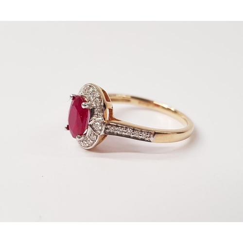 58 - A BEAUTIFUL 9CT YELLOW GOLD RUBY AND DIAMOND HALO RING, with a stunning central oval shaped ruby sto... 