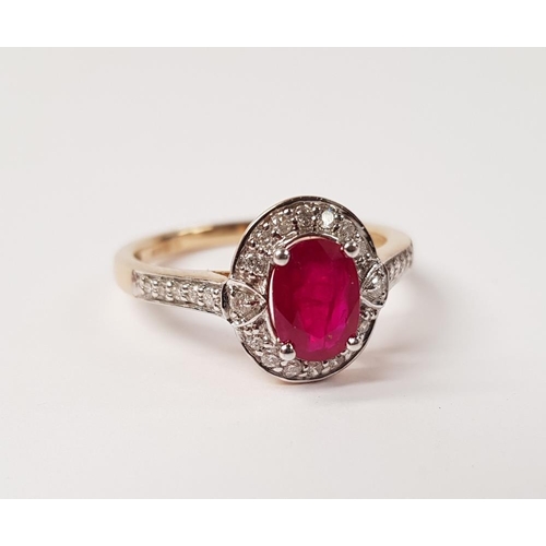 58 - A BEAUTIFUL 9CT YELLOW GOLD RUBY AND DIAMOND HALO RING, with a stunning central oval shaped ruby sto... 