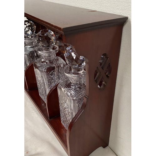 63 - AN EDWARDIAN MAHOGANY THREE BOTTLE DECANTER TABLE TOP STAND, with inlaid detail and pierced sides, c... 