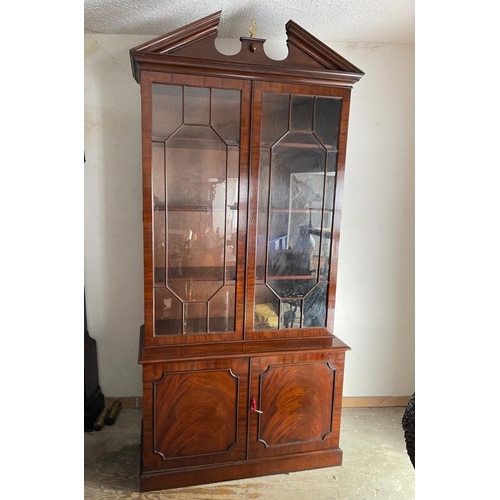 72 - A GOOD QUALITY MAHOGANY GLAZED BOOKCASE, with broken temple pediment, over a pair of astragal glazed... 