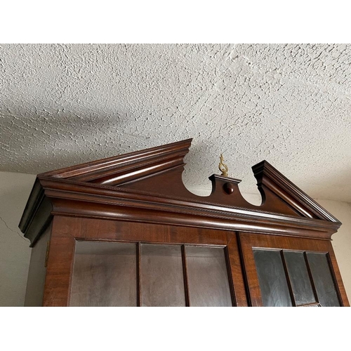 72 - A GOOD QUALITY MAHOGANY GLAZED BOOKCASE, with broken temple pediment, over a pair of astragal glazed... 