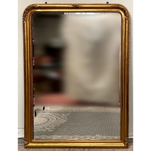 79 - A VERY FINE GILT OVER-MANTLE WALL MIRROR, with floral design to the curved top corners and a bead tr... 