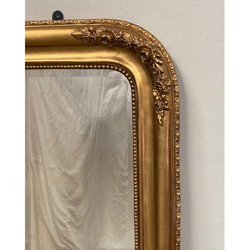 79 - A VERY FINE GILT OVER-MANTLE WALL MIRROR, with floral design to the curved top corners and a bead tr... 