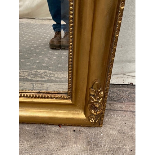 79 - A VERY FINE GILT OVER-MANTLE WALL MIRROR, with floral design to the curved top corners and a bead tr... 