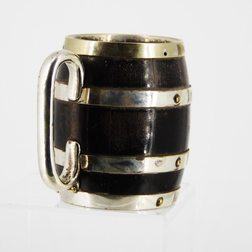 86 - A LATE 19TH CENTURY COOPERED WOODEN MUG, in the form of a barrel, with silver plated bands and handl... 