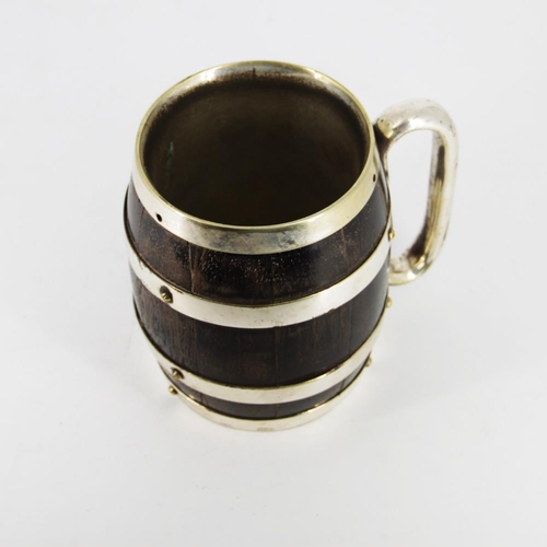 86 - A LATE 19TH CENTURY COOPERED WOODEN MUG, in the form of a barrel, with silver plated bands and handl... 