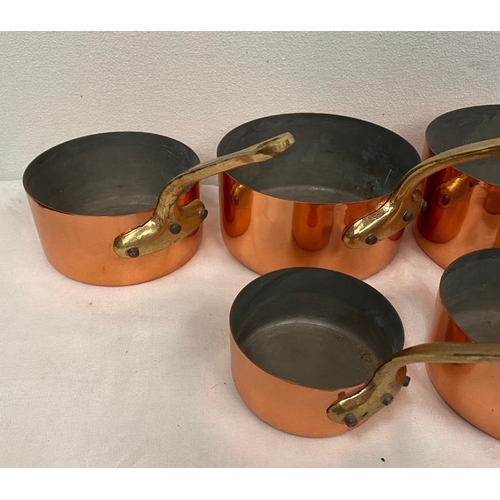 93 - A SET OF FIVE HEAVY COPPER SAUCEPANS, each with brass handle, in very good condition