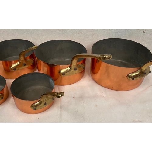 93 - A SET OF FIVE HEAVY COPPER SAUCEPANS, each with brass handle, in very good condition