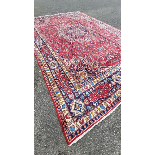 145 - A VERY FINE PERSIAN MASHAD FLOOR RUG, with brightly coloured red main ground, with indigo, pale blue... 