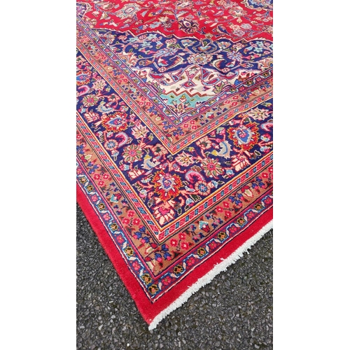 146 - A VIBRANT PERSIAN MASHAD FLOOR RUG, with central medallion surrounded by dense intertwined floral an... 