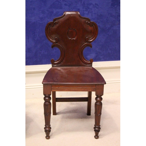 22 - A FINE MATCHING PAIR OF 19TH CENTURY IRISH MAHOGANY HALL CHAIRS, with carved scroll motif to the bac... 