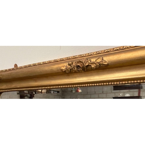 26 - A GOOD QUALITY GILT OVERMANTLE / OVER CONSOLE MIRROR, with rounded corners to the top and decorated ... 