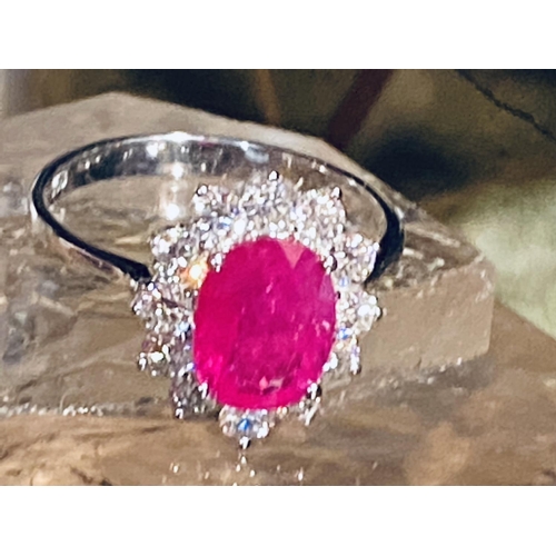 35 - A STUNNING 18CT WHITE GOLD BURMESSE RUBY & DIAMOND CLUSTER RING; the centrally placed Burmese ruby w... 