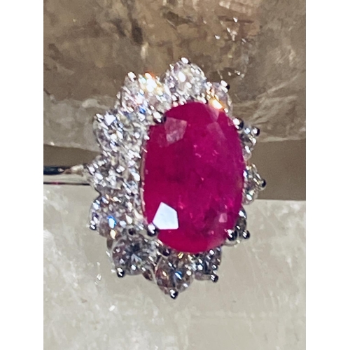 35 - A STUNNING 18CT WHITE GOLD BURMESSE RUBY & DIAMOND CLUSTER RING; the centrally placed Burmese ruby w... 