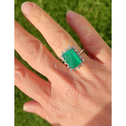 50 - A UNIQUE 18CT GOLD EMERALD AND DIAMOND CLUSTER RING, with beautiful 4.7ct central emerald surrounded... 