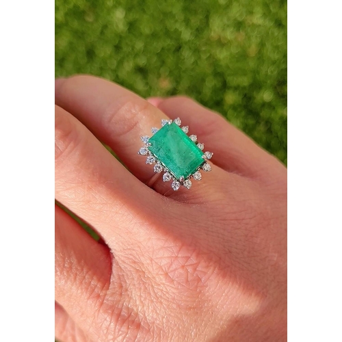 50 - A UNIQUE 18CT GOLD EMERALD AND DIAMOND CLUSTER RING, with beautiful 4.7ct central emerald surrounded... 