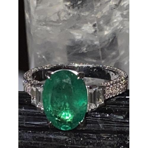 69 - AN 18CT WHITE GOLD NATURAL COLUMBIAN EMERALD & DIAMOND RING, the ring has a centrally set oval shape... 