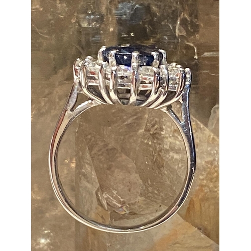 93 - AN 18CT WHITE GOLD SAPPHIRE & DIAMOND CLUSTER RING, with a central oval shaped sapphire stone weighi... 