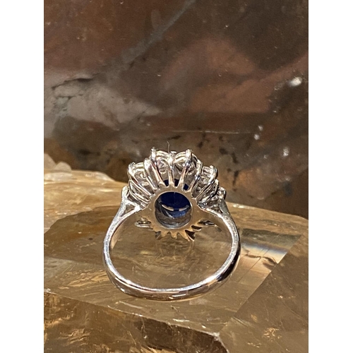 93 - AN 18CT WHITE GOLD SAPPHIRE & DIAMOND CLUSTER RING, with a central oval shaped sapphire stone weighi... 