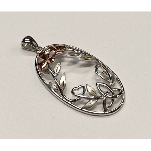 212 - A STERLING SILVER NECKLACE PENDANT, oval in shape with open work in the form of two rose gold colour... 