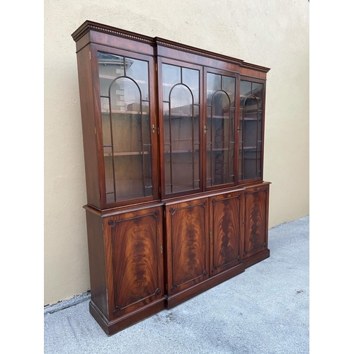 108 - A LARGE MAHOGANY BREAK-FRONT GLAZED LIBRARY BOOKCASE, the pediment with dentil moulding, each of the... 