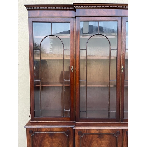 108 - A LARGE MAHOGANY BREAK-FRONT GLAZED LIBRARY BOOKCASE, the pediment with dentil moulding, each of the... 