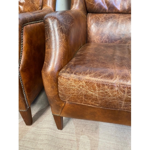 13 - A GOOD QUALITY PAIR OF TAN LEATHER WINGBACK ARMCHAIRS. Dimensions: 71cm x 76cm x 96cm approx.