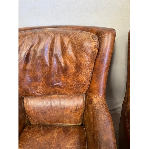 13 - A GOOD QUALITY PAIR OF TAN LEATHER WINGBACK ARMCHAIRS. Dimensions: 71cm x 76cm x 96cm approx.